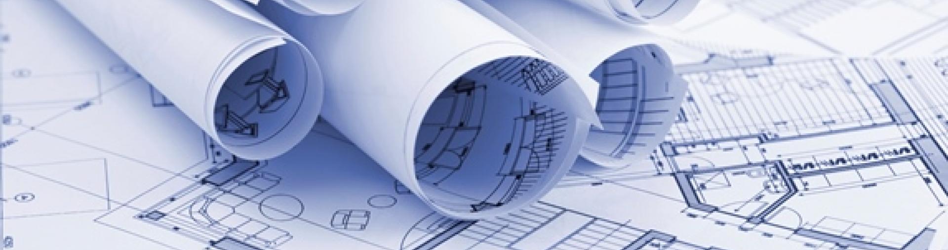 Image of building plans rolled up over a desk