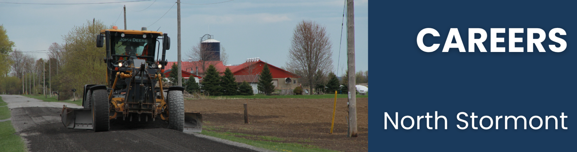 a grader driving down a gravel street