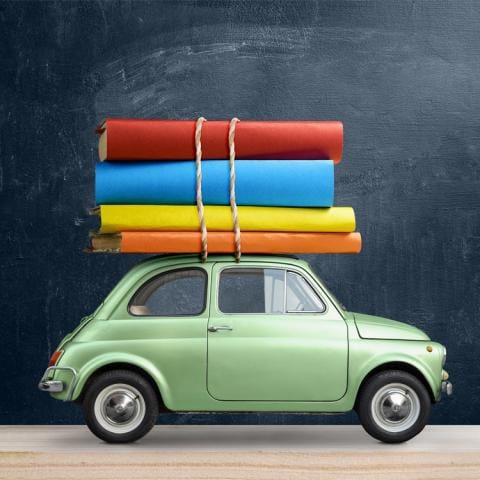 Small green car carrying books on roof