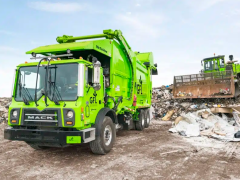 A picture of a garbage truck in a landfill